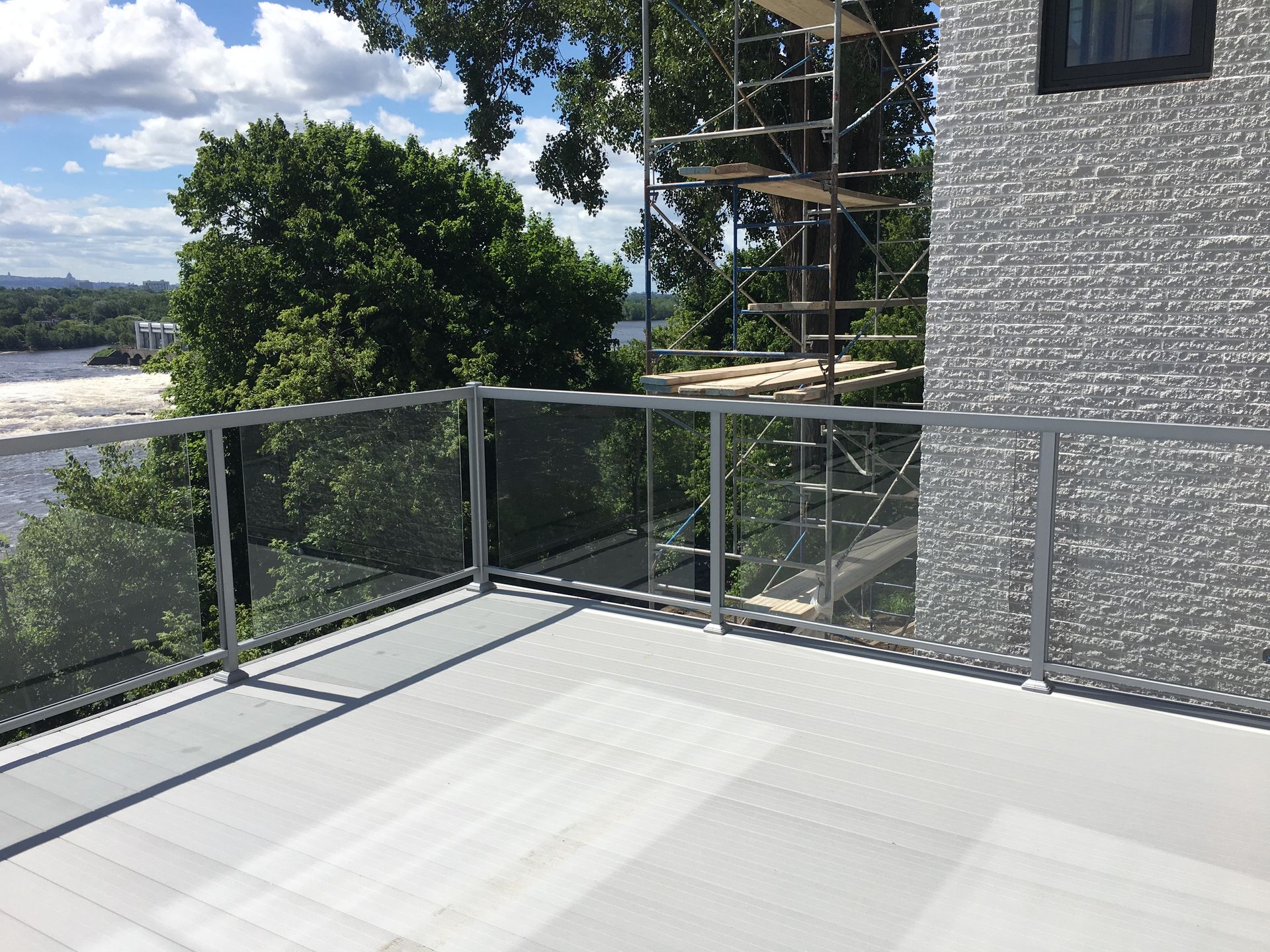 Un balcon avec une balustrade en verre donnant sur un plan d'eau.