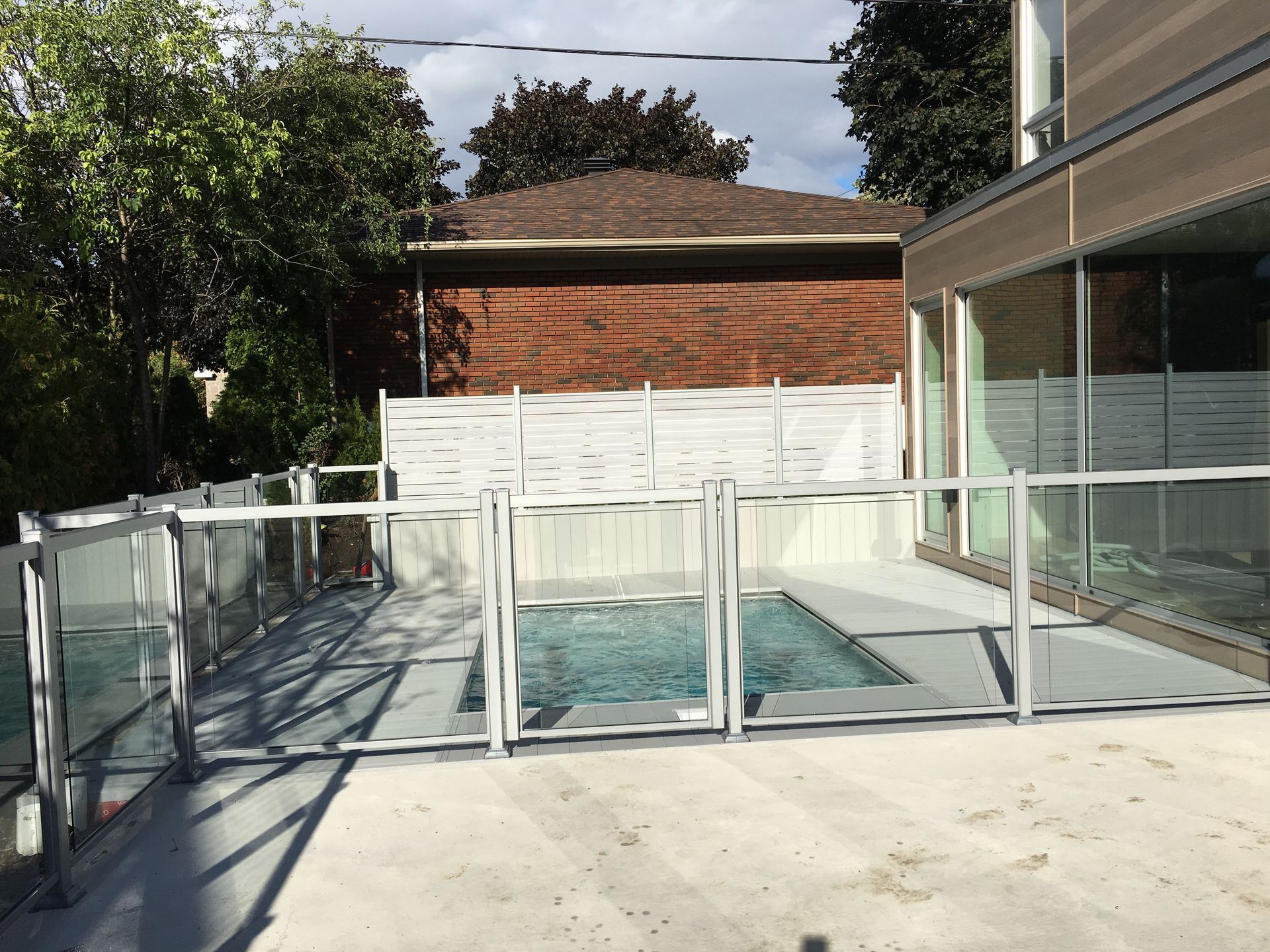 Une piscine entourée d'une clôture en verre