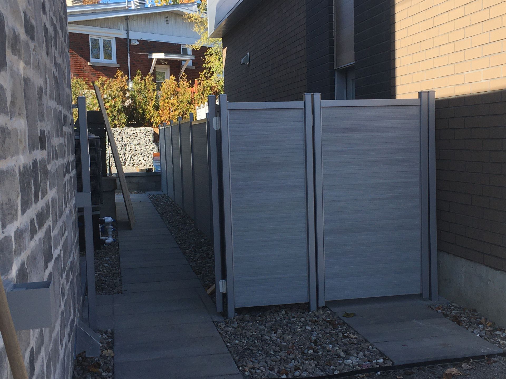 Une clôture le long d'un trottoir entre deux bâtiments