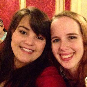 Two women are posing for a picture together and smiling for the camera.