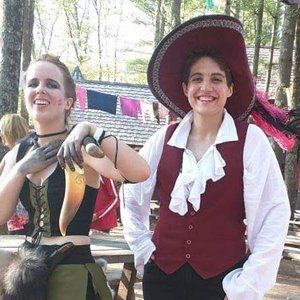 A woman in a pirate costume is standing next to a man in a pirate costume.