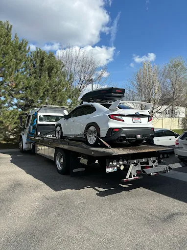 Towing car on flatbed tow truck