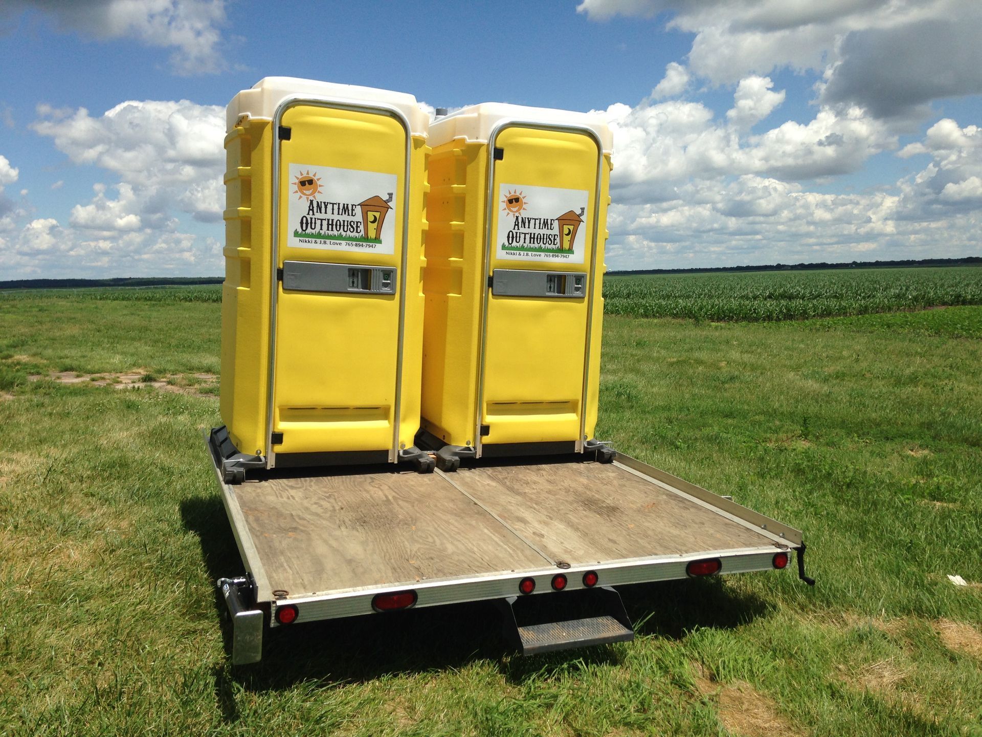 Two yellow portable toilets on a trailer