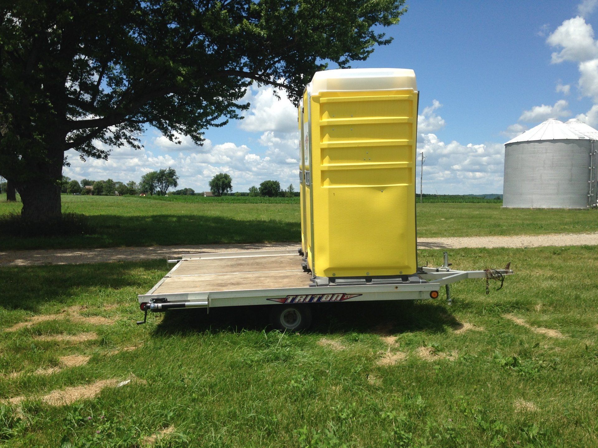 Yellow portable toilet on a trailer