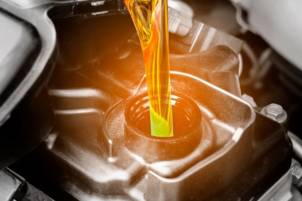 Yellow Oil Being Poured Into a Car Engine's Oil Fill Cap — North Queensland Independant Fuel Services in Rockhampton, QLD