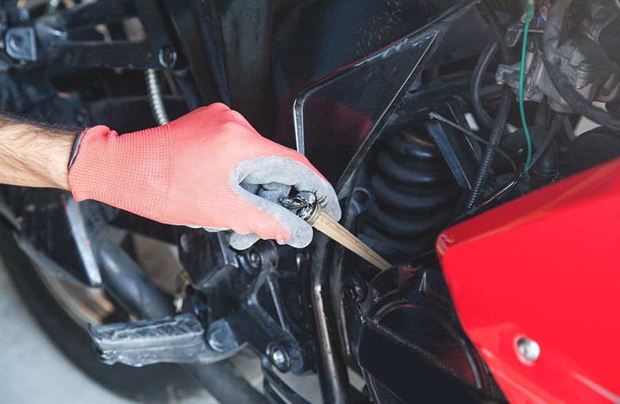 A Person Checking the Engine Oil of Motorcycle — North Queensland Independant Fuel Services in Slade Point, QLD