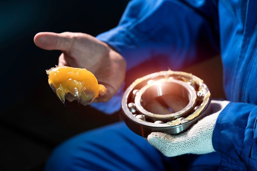 A Man is Holding a Ball Bearing With Grease in His Hand — North Queensland Independant Fuel Services in Slade Point, QLD