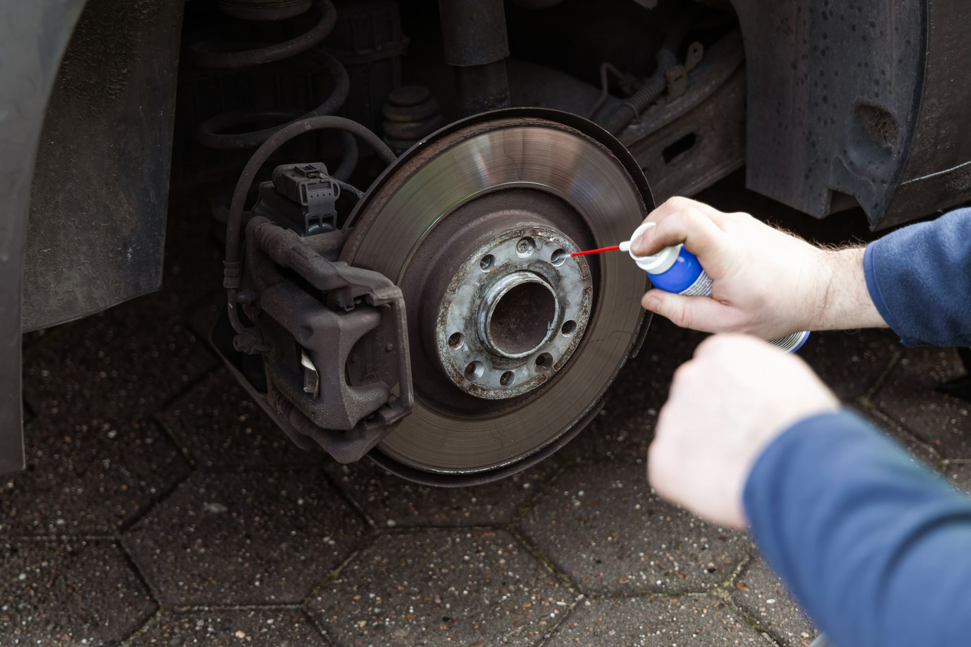 Person Spraying Brake Rotor on a Car Wheel — North Queensland Independant Fuel Services in Rockhampton, QLD