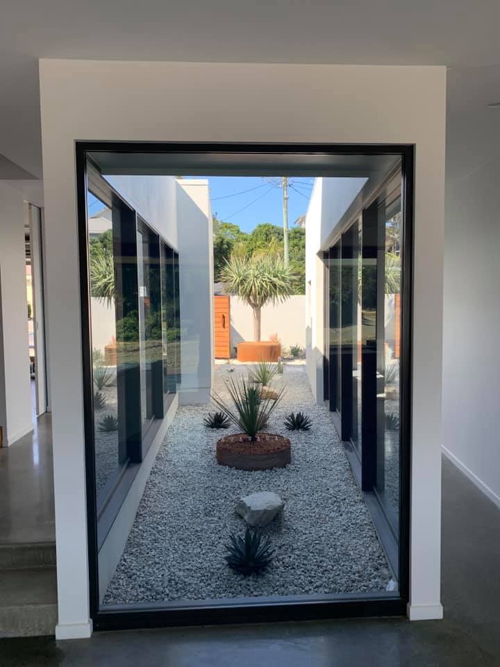 A View Of A Garden Through A Window In A House — Creative Landscapes Coffs Harbour In Korora, NSW