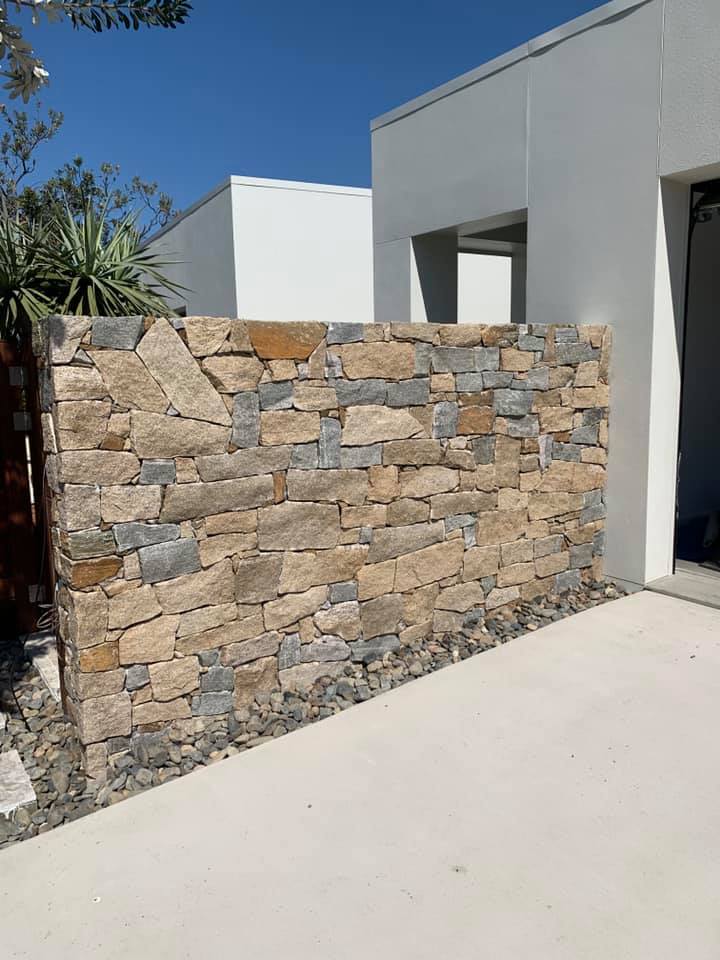 A Large Stone Wall Is In Front Of A White House — Creative Landscapes Coffs Harbour In Korora, NSW