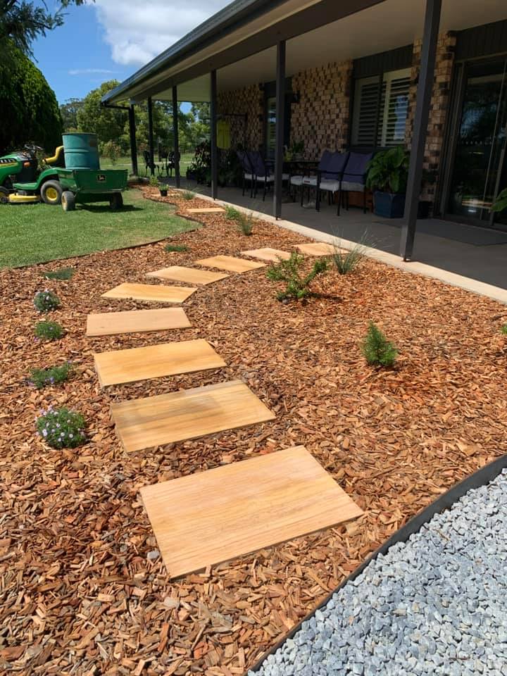 A Wooden Walkway Leading To A House With A Lawn Mower In The Background — Creative Landscapes Coffs Harbour In Korora, NSW