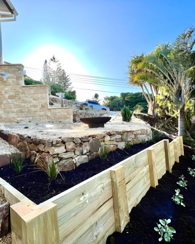 A Wooden Fence Surrounds A Lush Green Garden — Creative Landscapes Coffs Harbour In Korora, NSW
