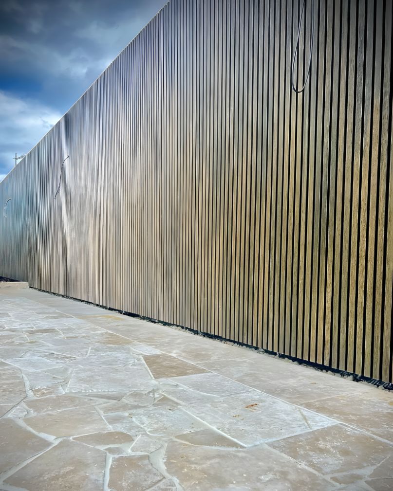 A Large Wooden Fence With A Stone Walkway In Front Of It — Creative Landscapes Coffs Harbour In Woolgoolga, NSW