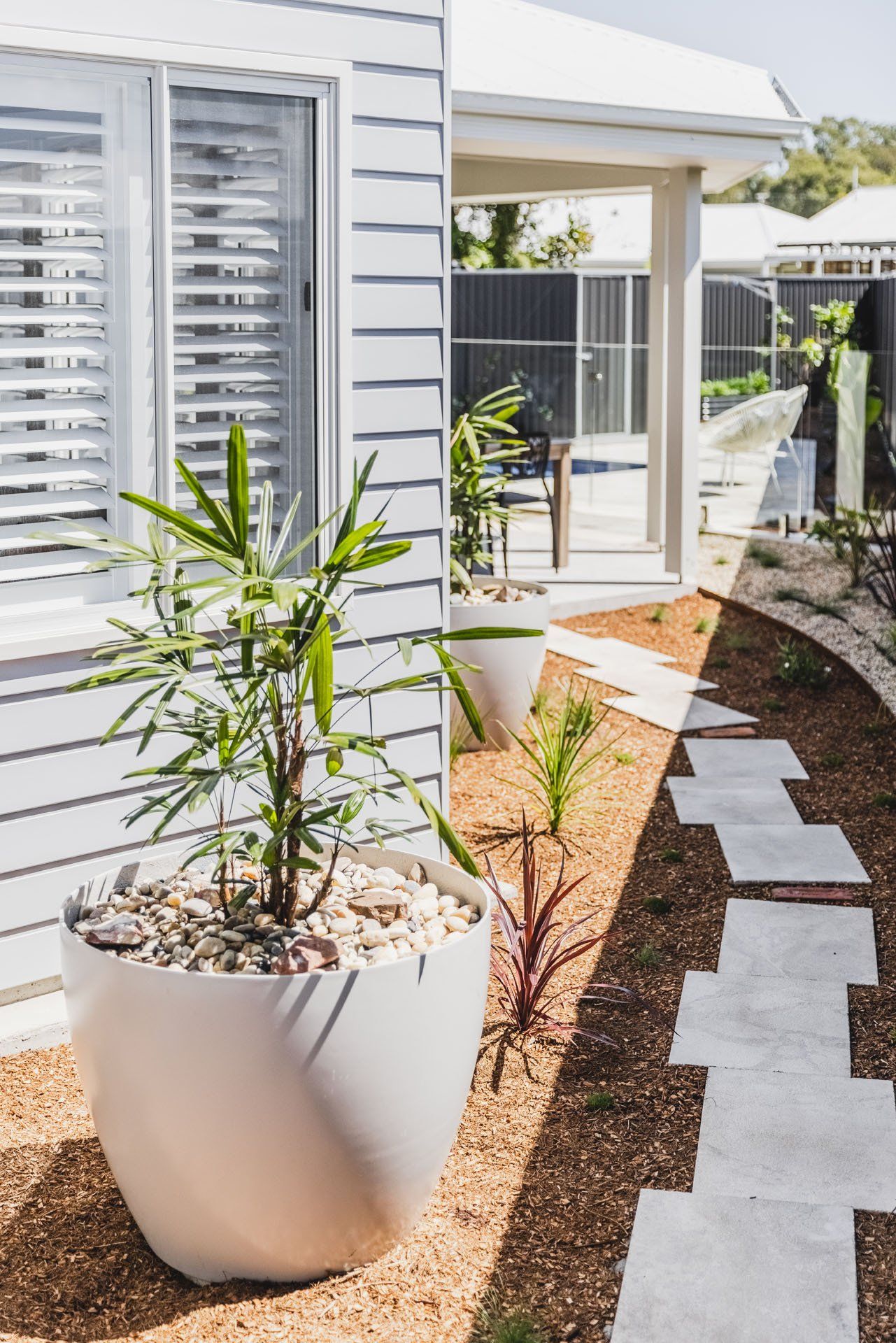 A Potted Plant Is Sitting In Front Of A White House — Creative Landscapes Coffs Harbour In Korora, NSW