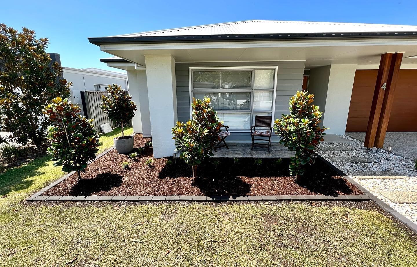 A White House With A Lush Green Lawn In Front Of It — Creative Landscapes Coffs Harbour In Korora, NSW