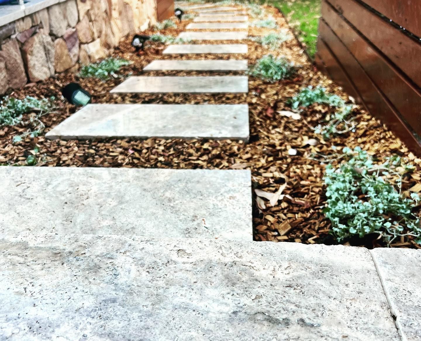A Stone Walkway With A Wooden Fence In The Background — Creative Landscapes Coffs Harbour In Korora, NSW