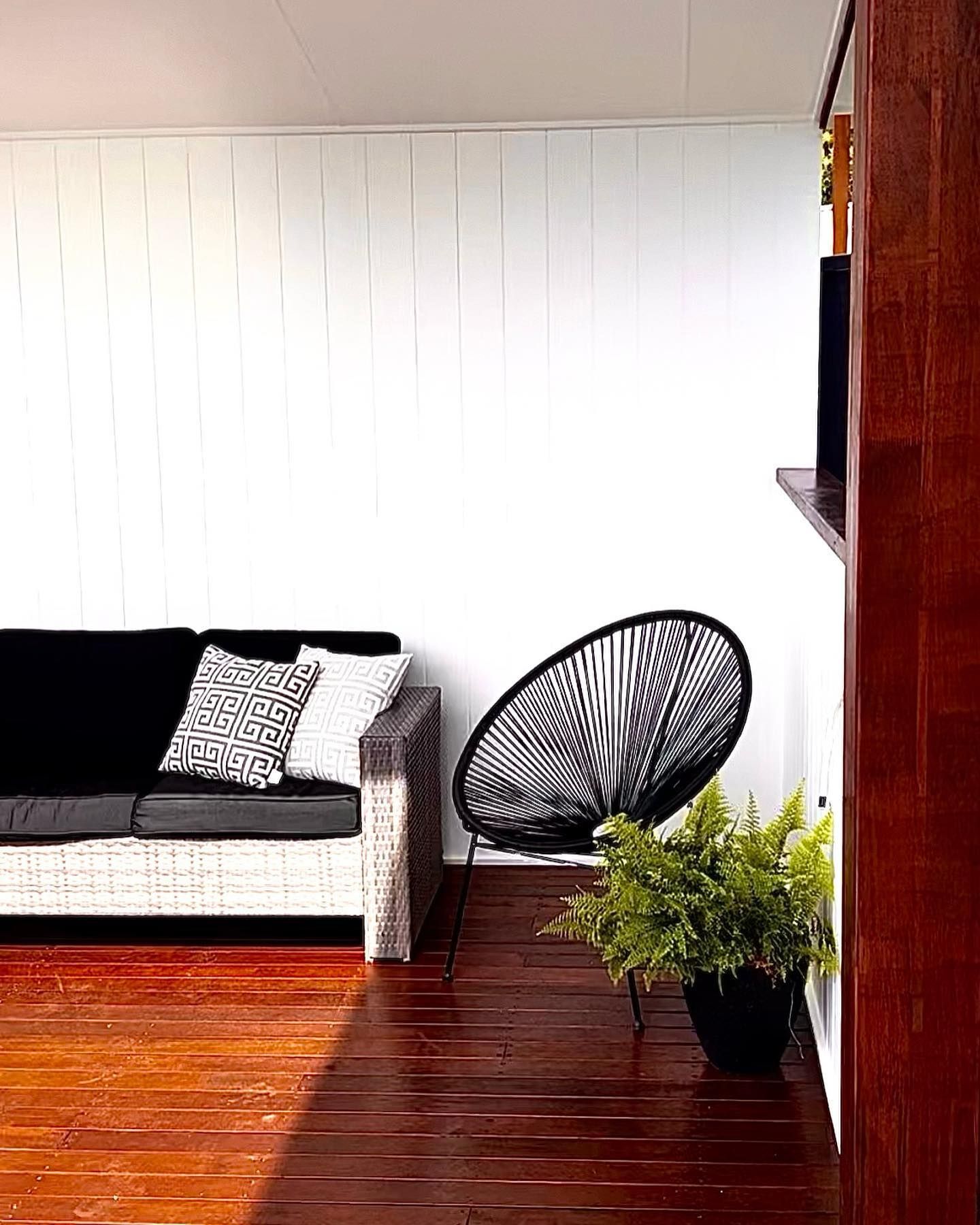 A Living Room With A Black Couch And A Black Chair — Creative Landscapes Coffs Harbour In Korora, NSW