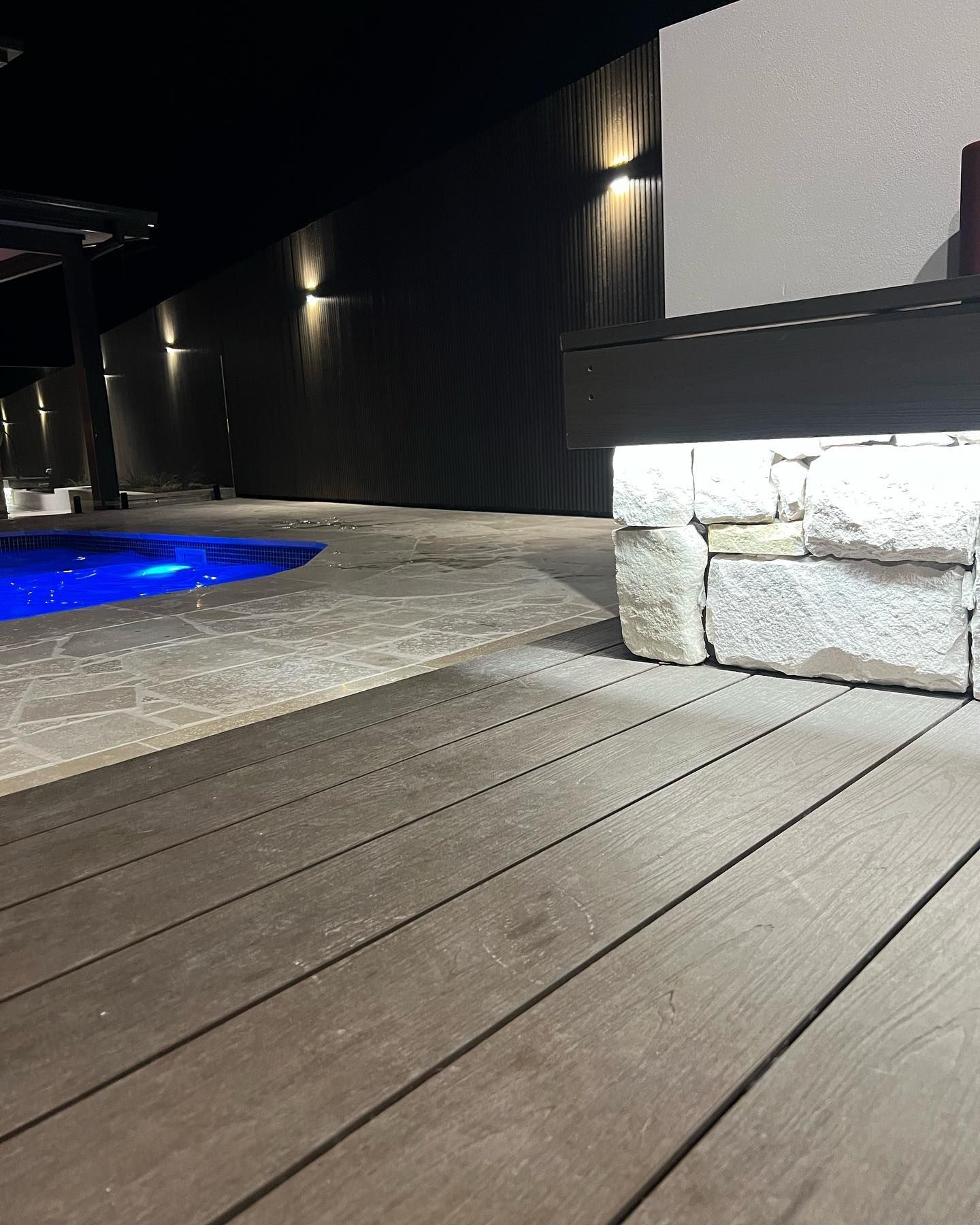 A Wooden Deck With A Swimming Pool In The Background — Creative Landscapes Coffs Harbour In Korora, NSW