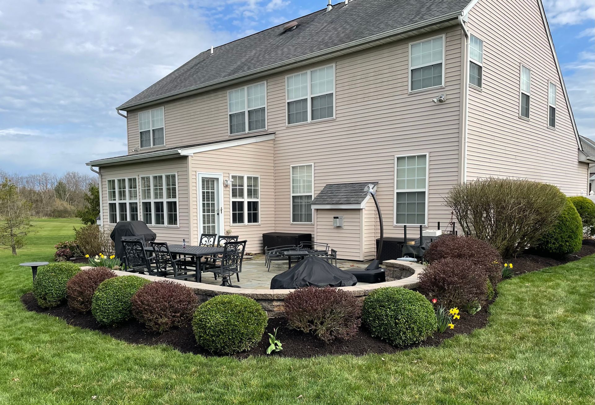 A large house with a patio area in front of it.