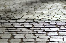 A close up of a cobblestone street with a lot of bricks.