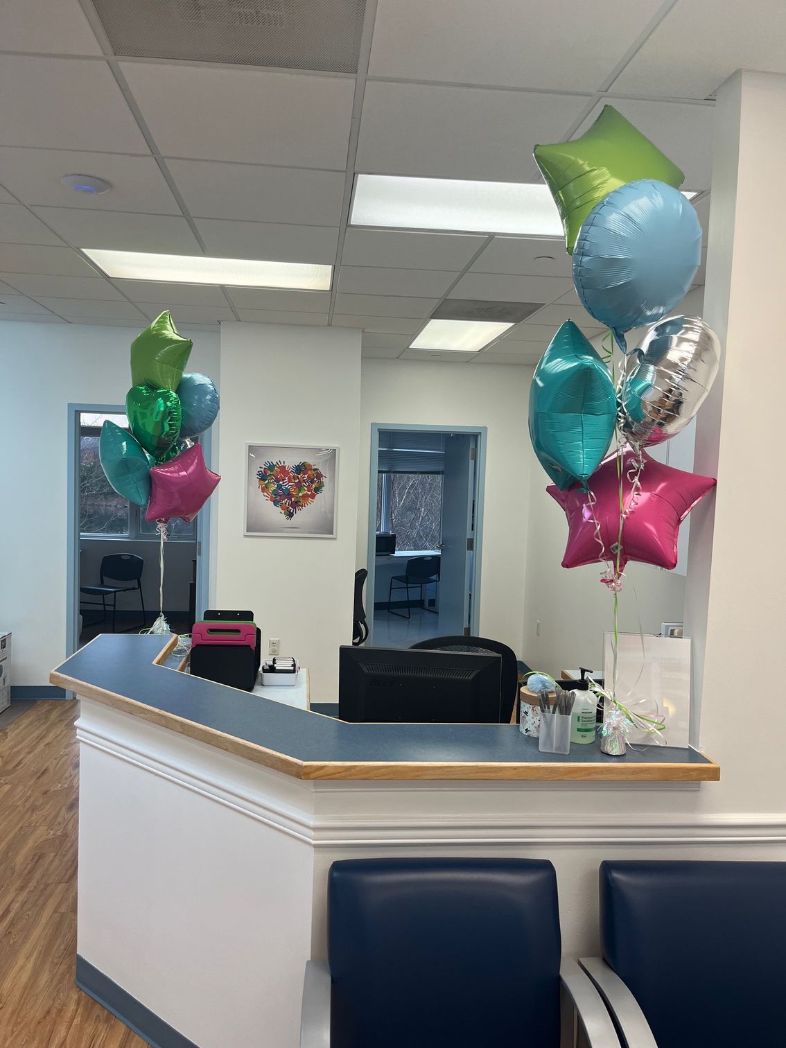 Inside office of Town Pediatrics. Reception desk with chairs and balloons.