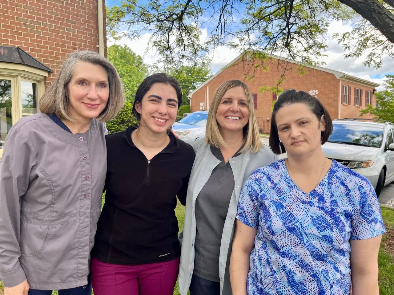 A group of women are posing for a picture in front of a building.