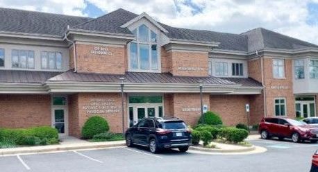 A large brick building with cars parked in front of it.