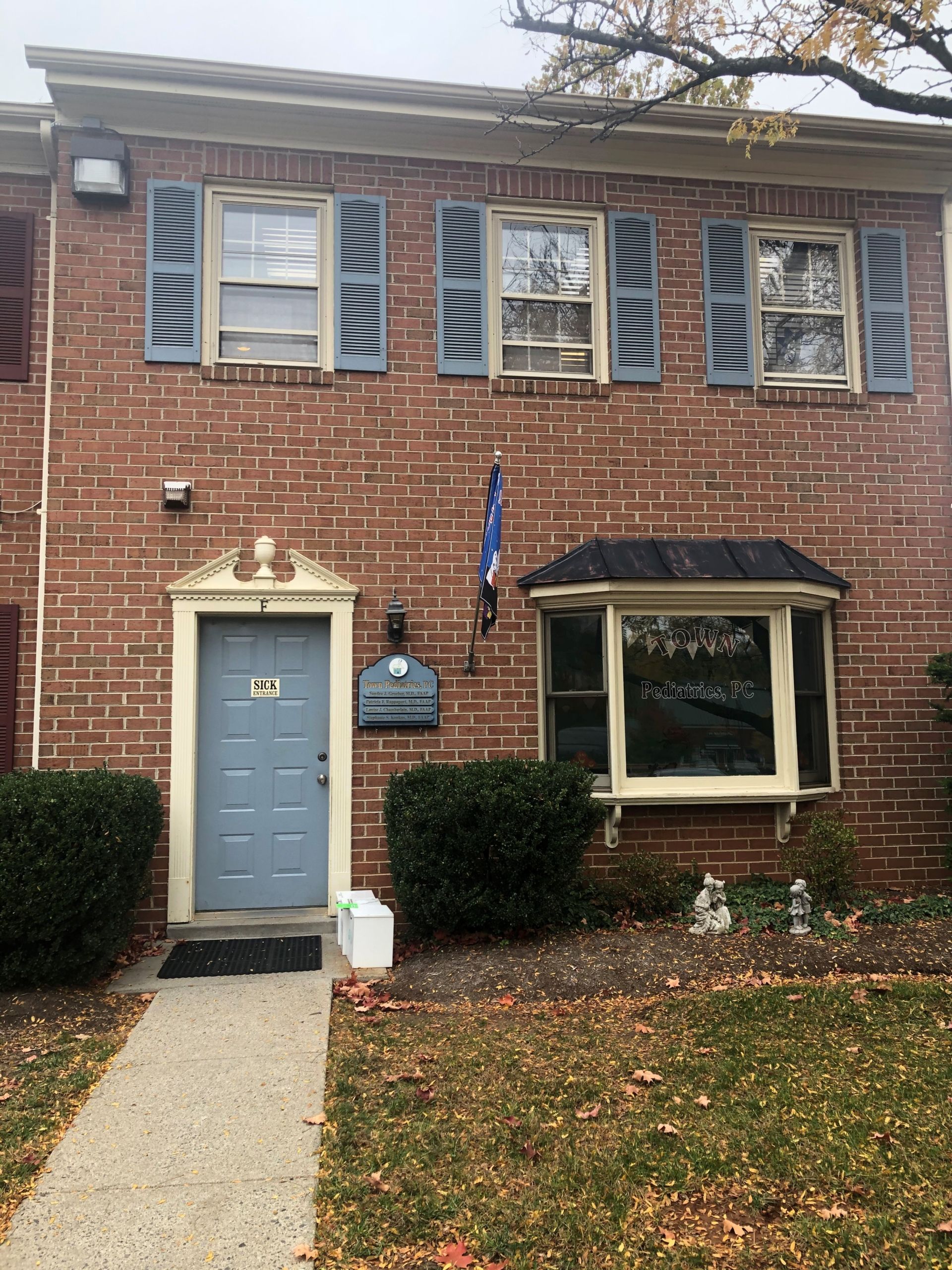 A brick house with blue shutters and a blue door