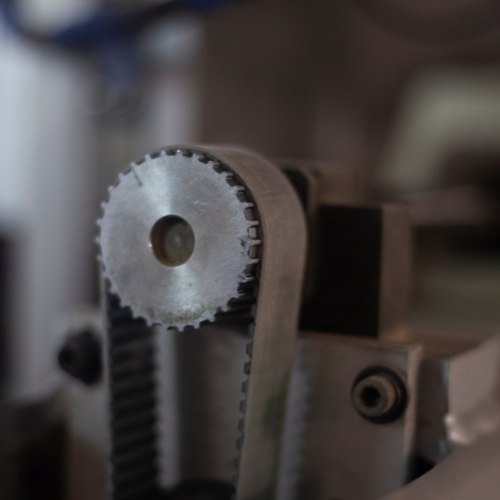 A close up of a machine with a belt and a gear.