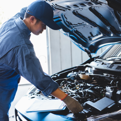 A man is working under the hood of a car