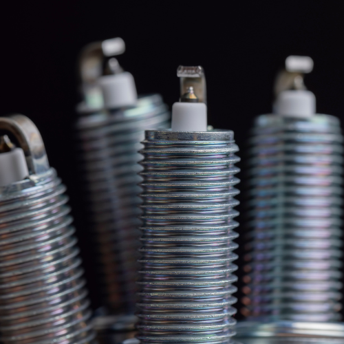 A close up of a group of spark plugs on a black background.