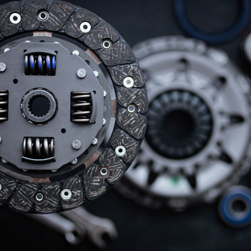 A close up of a clutch disc with a wrench in the background