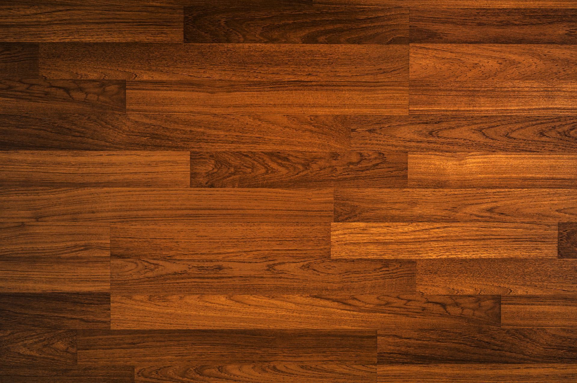 Brown wooden plank floor with varied grain and warm lighting
