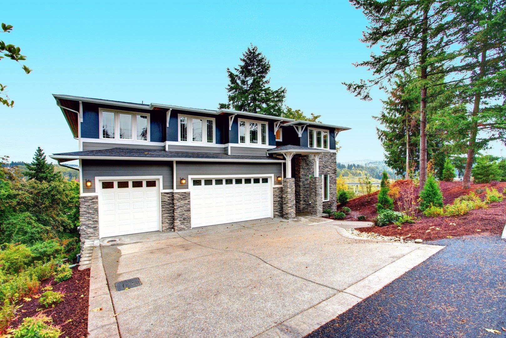 A large house with two garage doors and a driveway