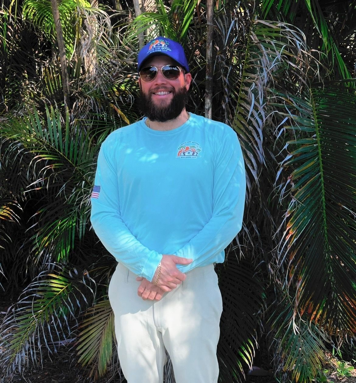 A man with a beard wearing sunglasses and a blue hat
