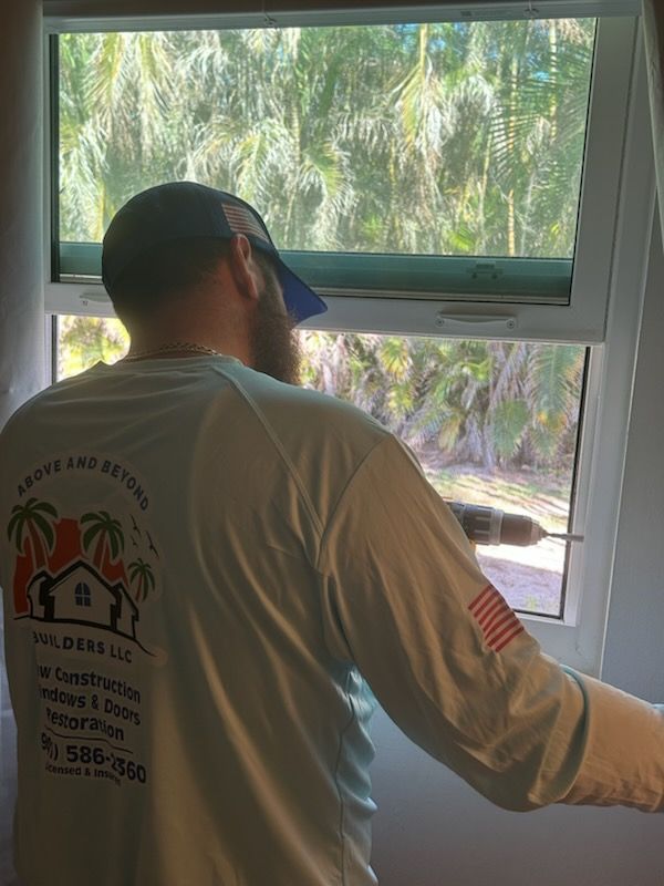 A man is working on a window with a drill.