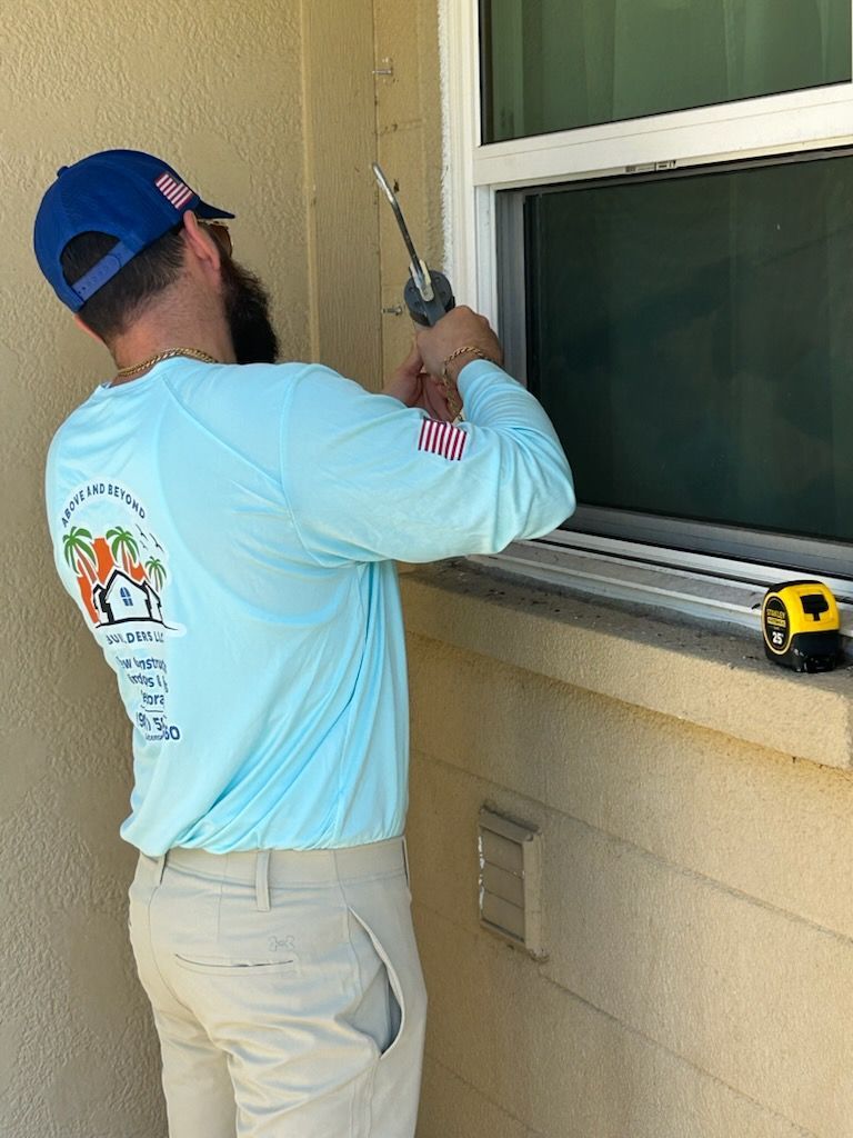 A man is measuring a window with a tape measure.