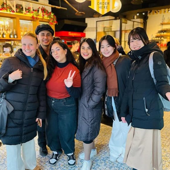 A group of people posing for a picture with one woman giving a peace sign