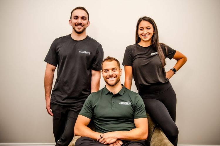 Four people in a fitness studio. Two women and two men. All are smiling.