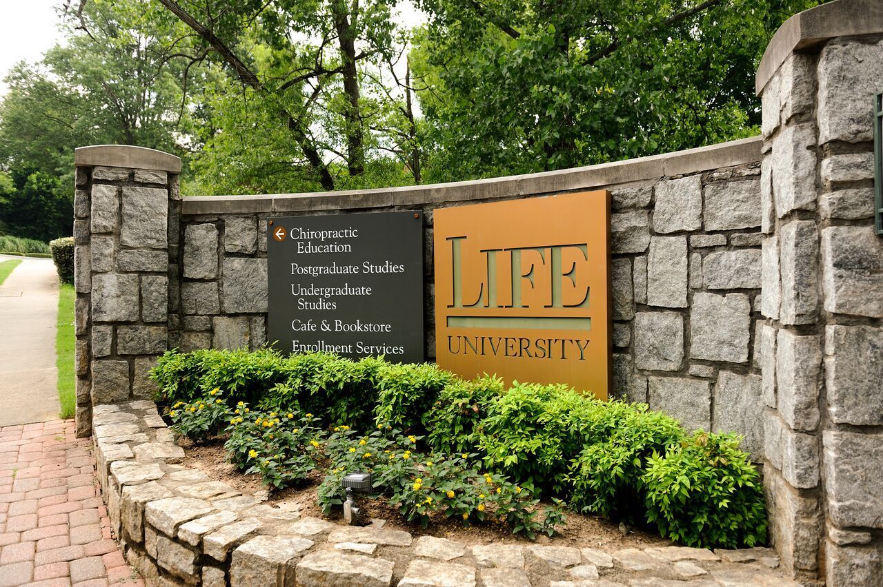 Stone wall with LIFE University sign and entrance.