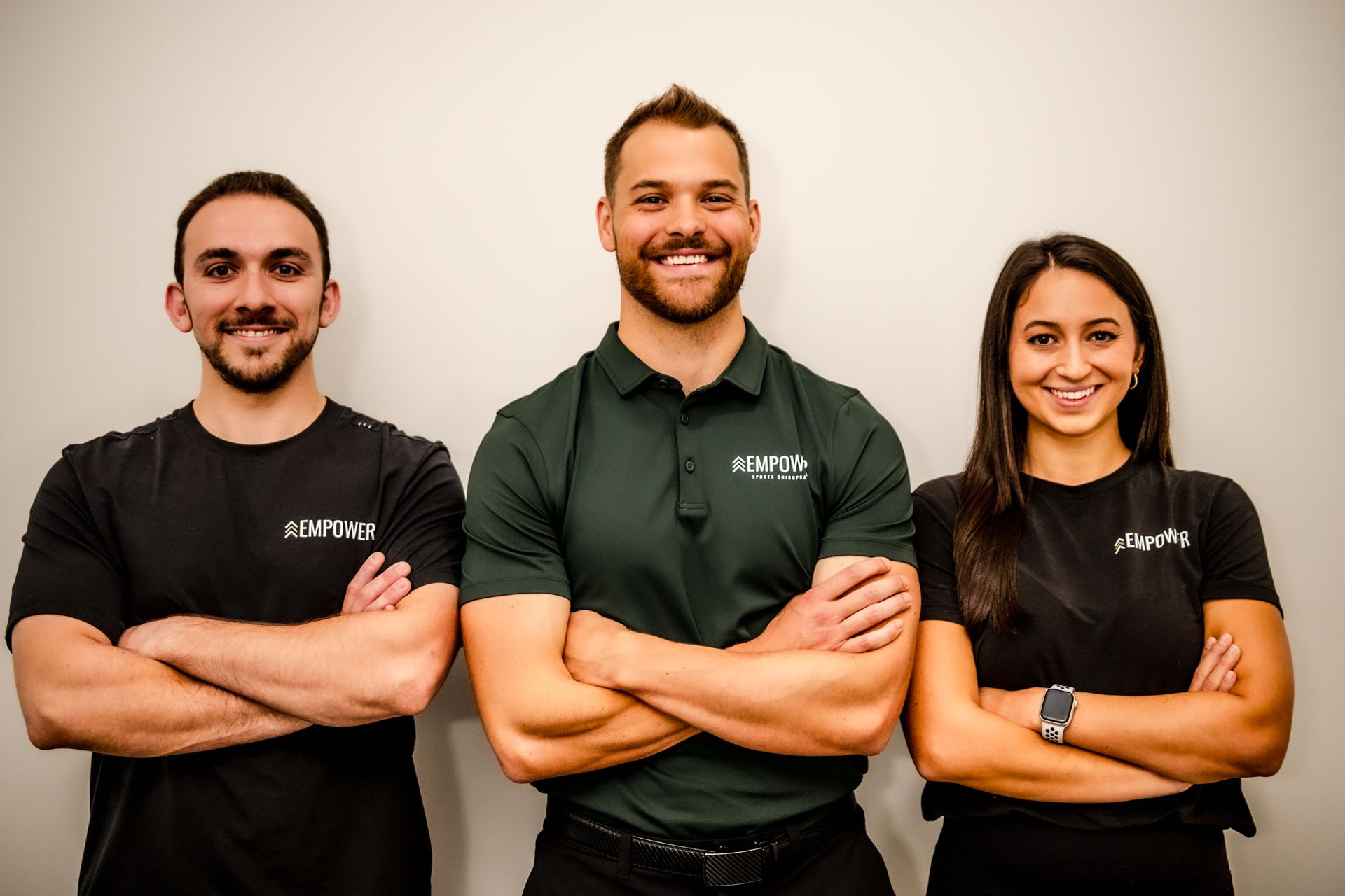 Four people in athletic wear pose inside a modern gym.
