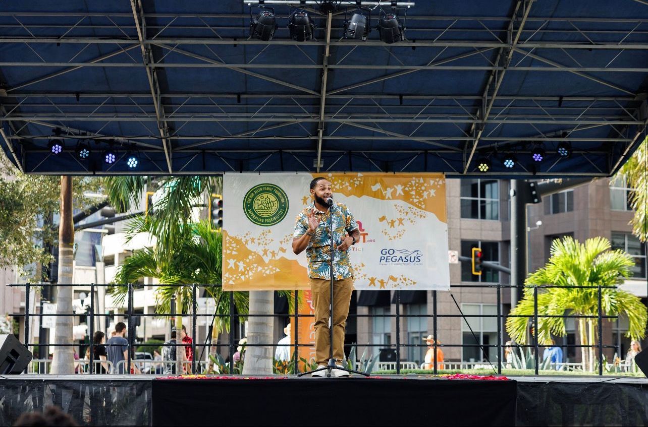 A man is standing on a stage holding a microphone.