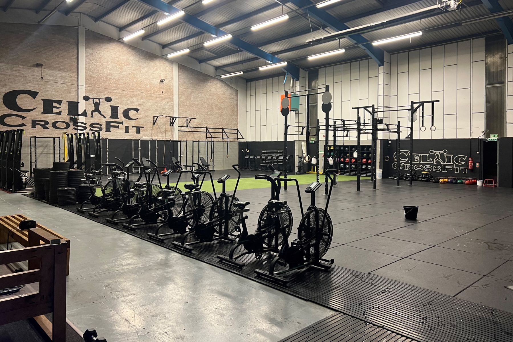 A row of exercise bikes are lined up in a gym.