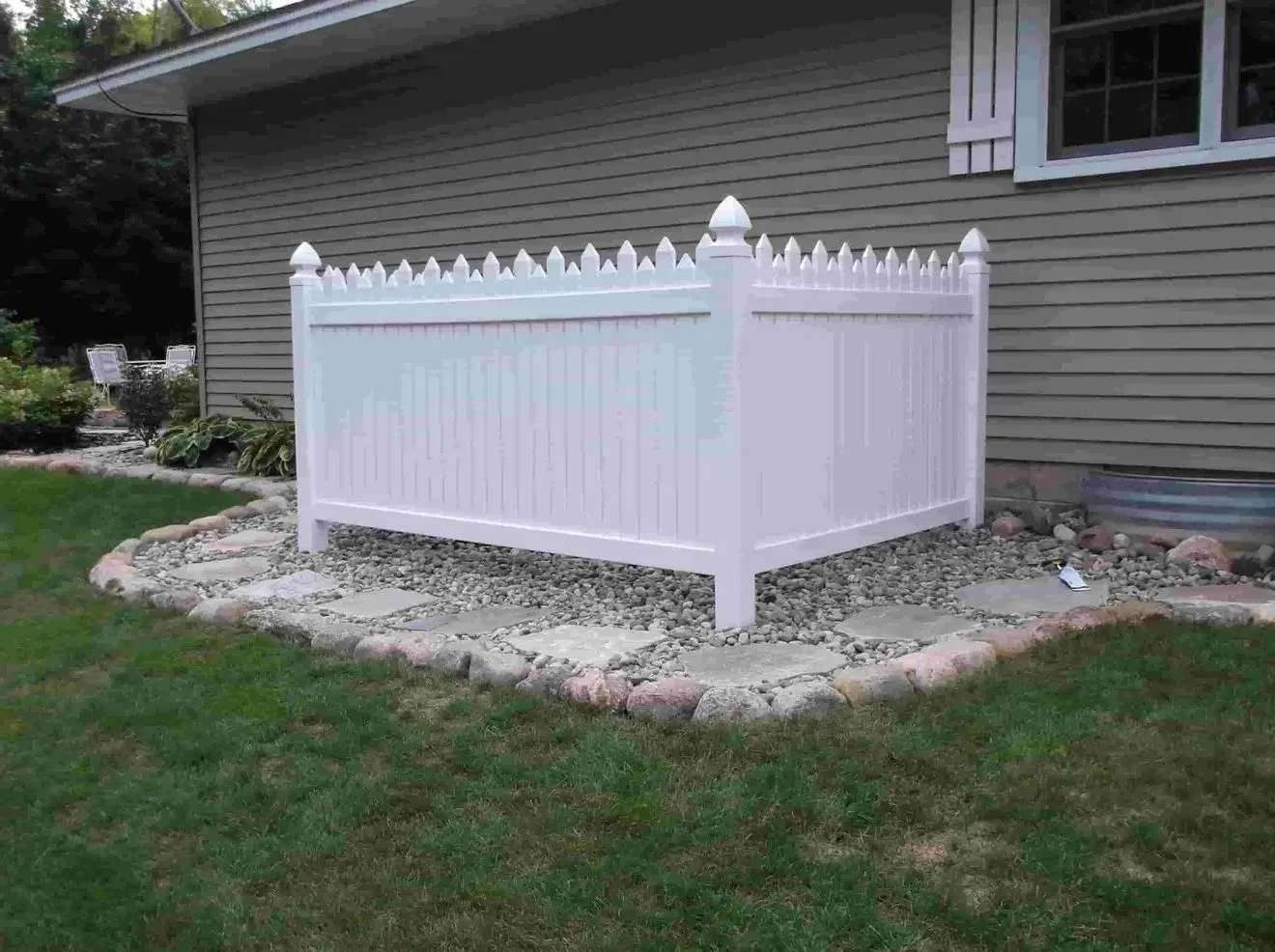 A white fence is sitting in front of a house.