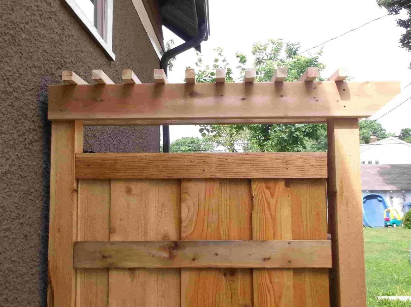 A wooden fence with a pergola on top of it