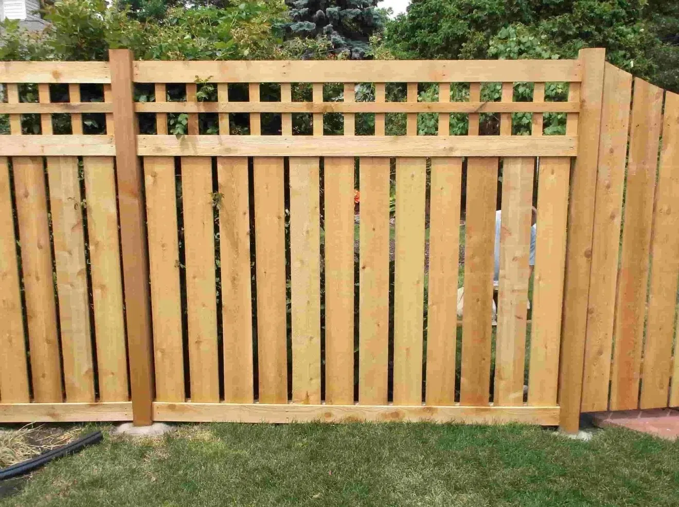 A wooden fence is sitting on top of a lush green lawn.