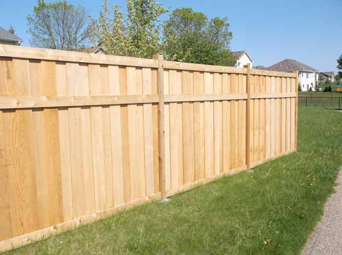 A wooden fence is sitting in the middle of a lush green field.