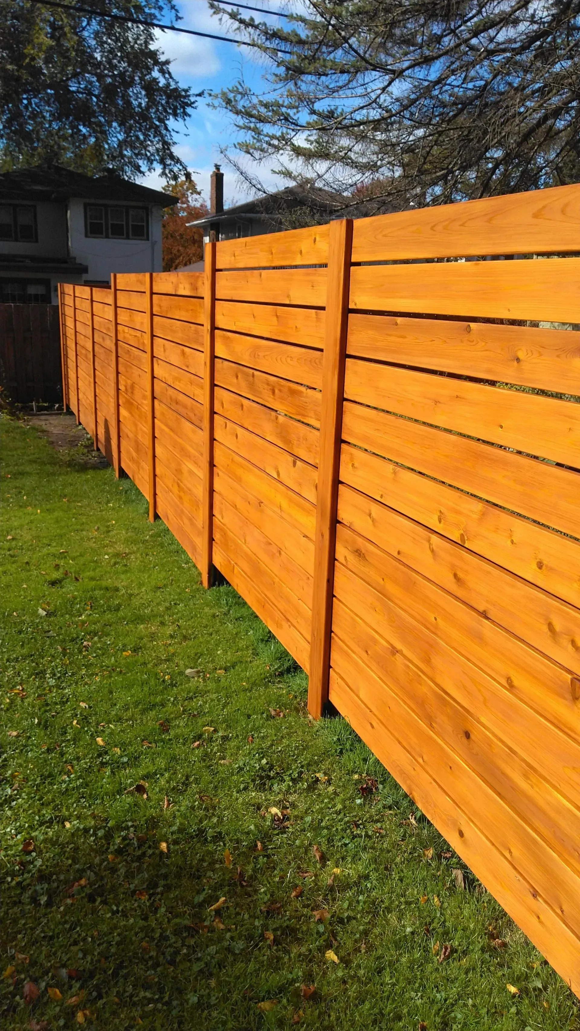 A wooden fence is sitting on top of a lush green lawn.