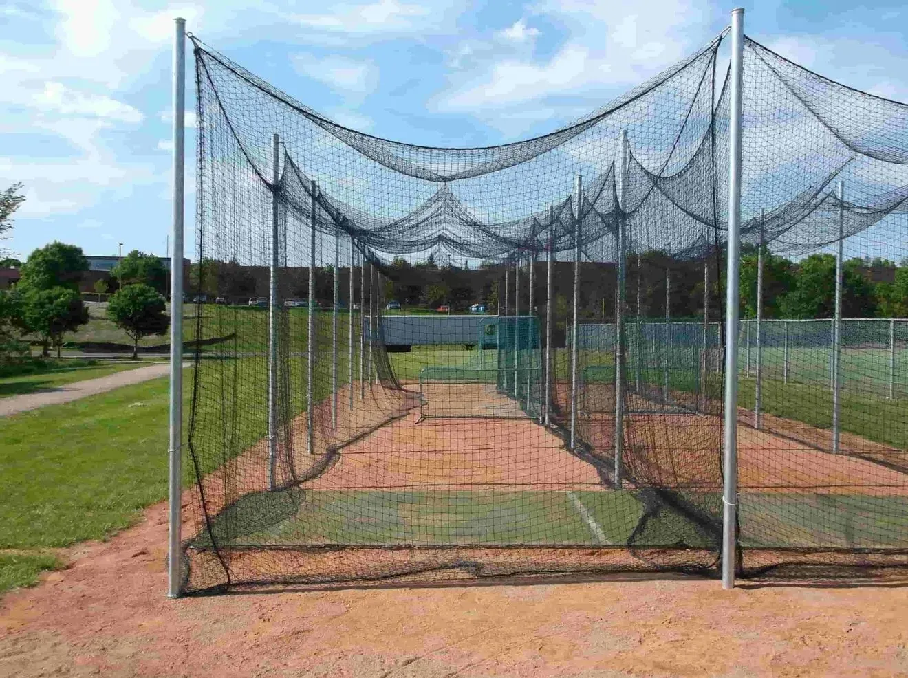 A cricket net is sitting on top of a dirt field.
