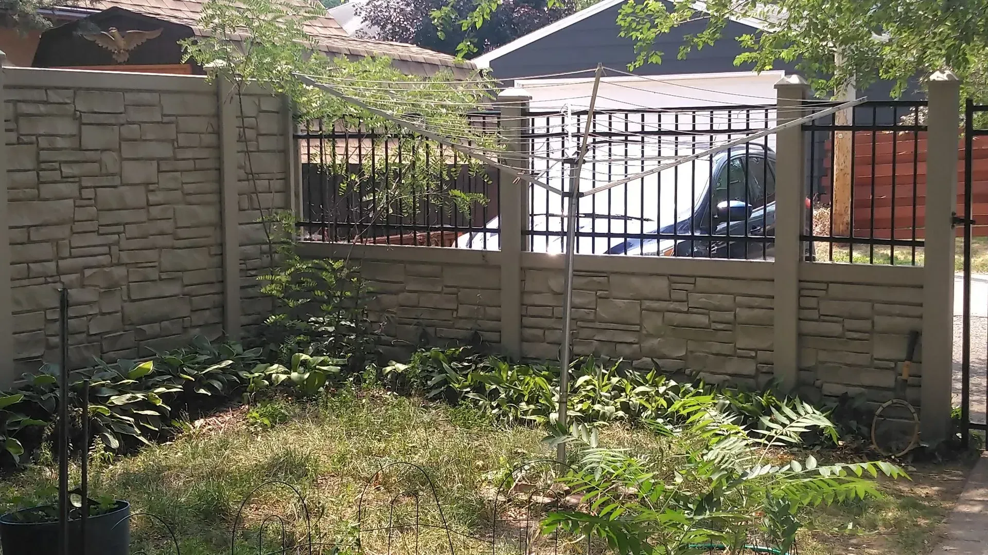 A garden with a fence and a gate in front of a house